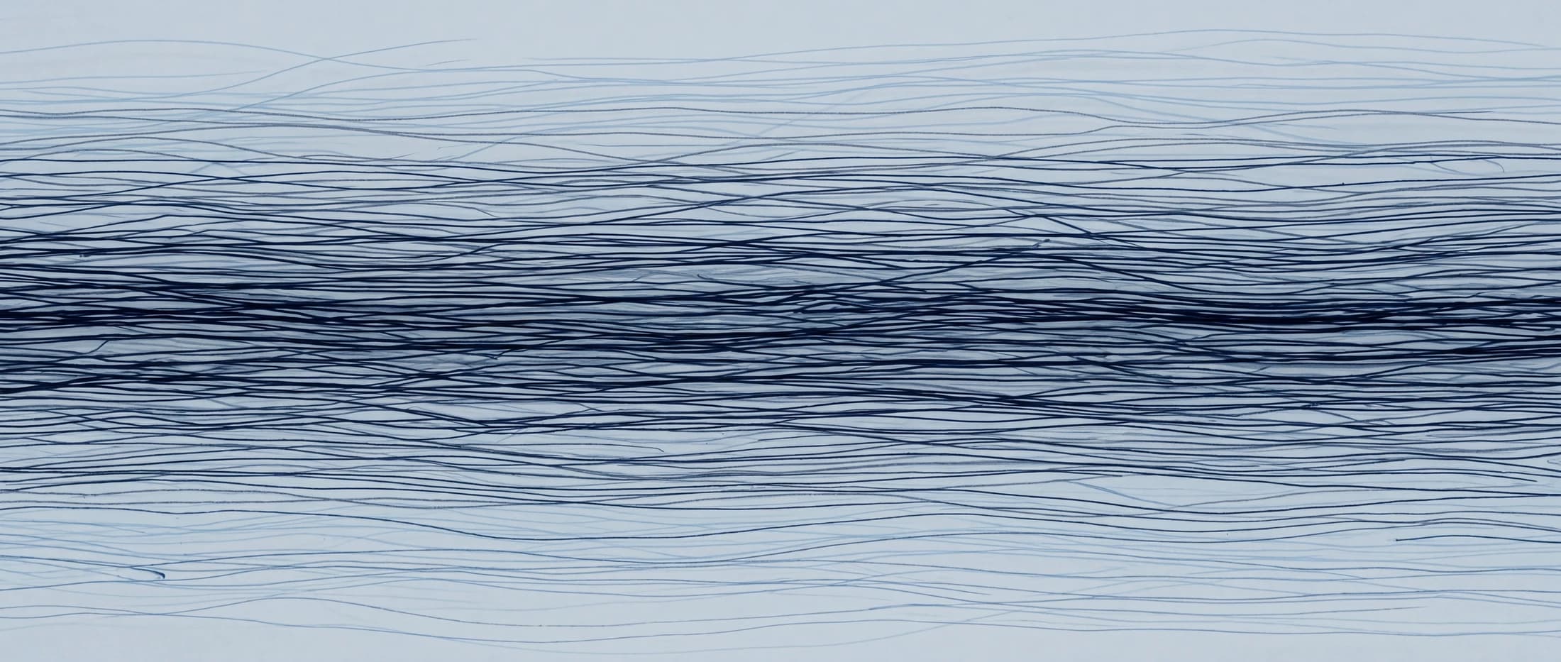 Navy ink drawn into a steady horizontal tide of fine filaments through pale water