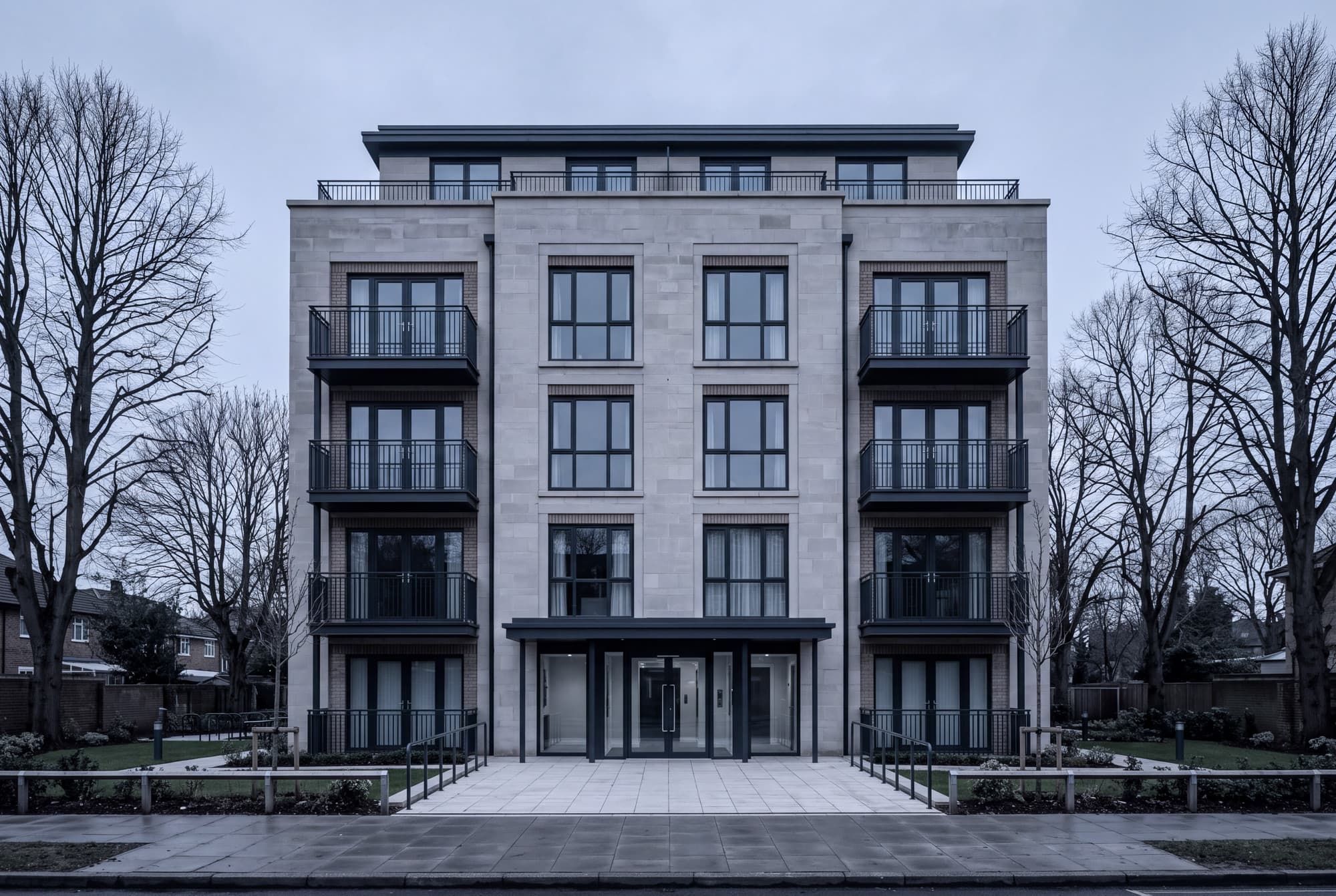 The communal entrance of a well-kept residential block on an overcast morning